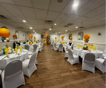 A fully decorated orange and blue baby shower in a venue for small gatherings
